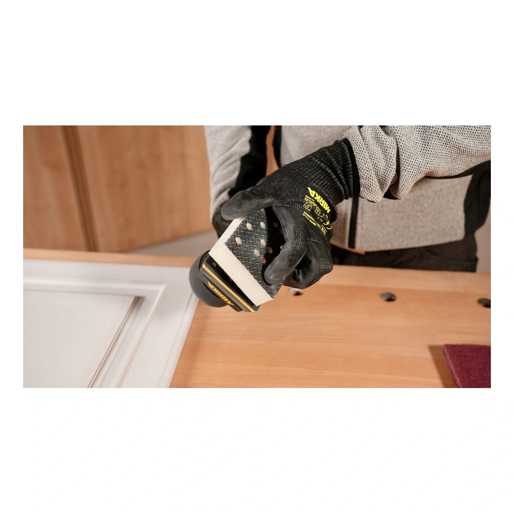 Gloved hand holding sander beside a wood panel