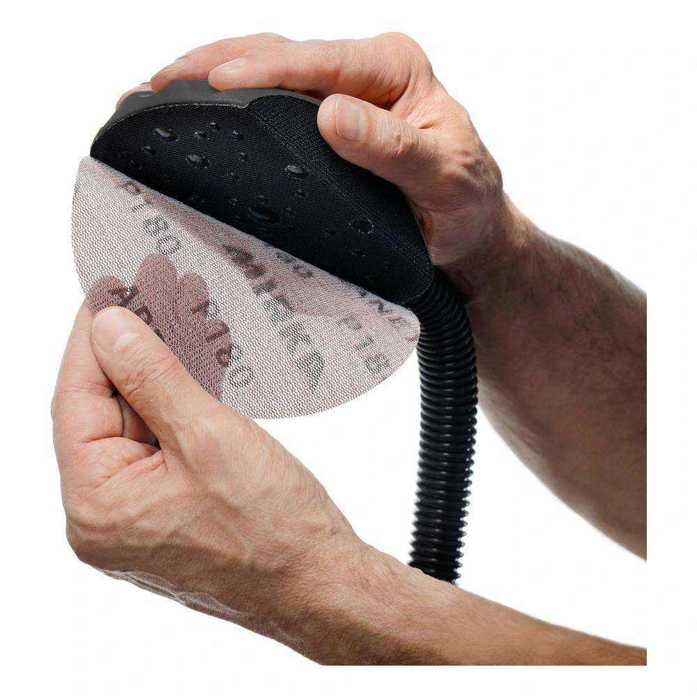 Hands hold black sanding block with hose
