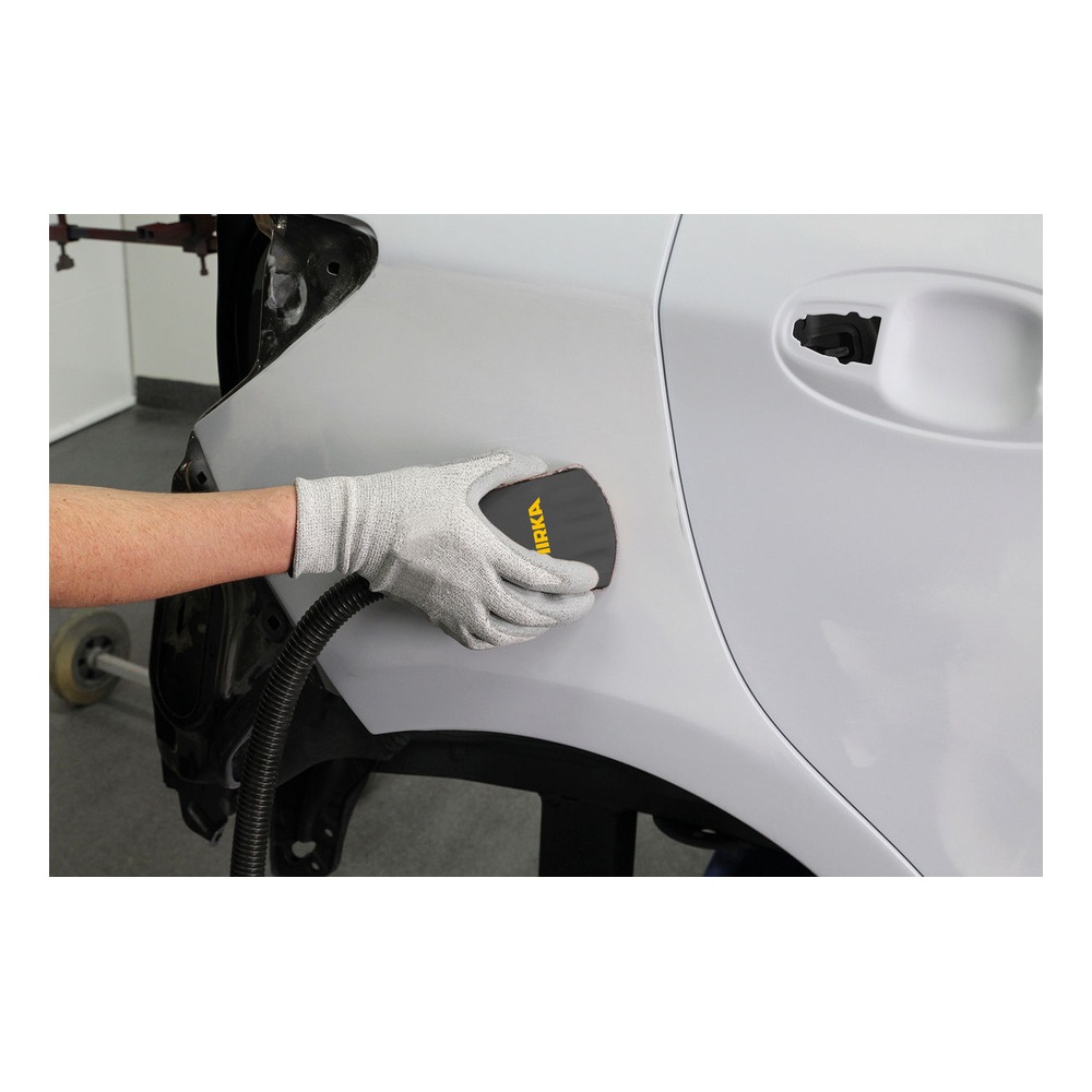 Gloved hand sanding a white car panel