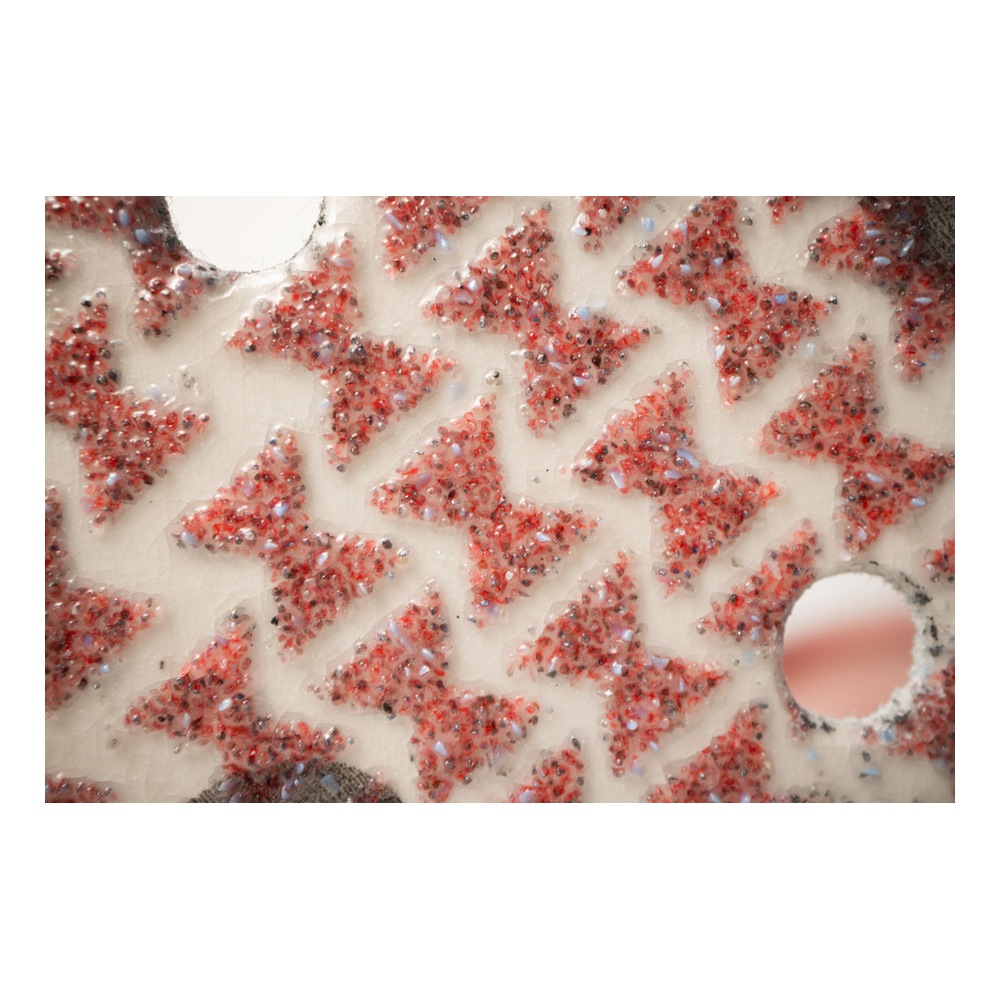 Close-up of red abrasive surface with holes