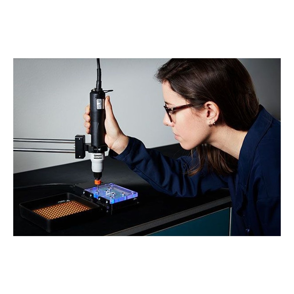 Person operating an electric screwdriver over a work fixture